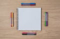 Notepad or notebook with Many colorful pens on brown wood table.using for education, business background