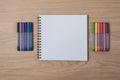 Notepad or notebook with Many colorful pens on brown wood table.using for education, business background