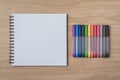 Notepad or notebook with Many colorful pens on brown wood table.using for education, business background Royalty Free Stock Photo