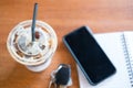 Notepad or notebook with pen, mobile phone and key car and cup of iced coffee. Royalty Free Stock Photo