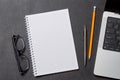 Notepad, office supplies and laptop on black leather workspace, top view with copy space Royalty Free Stock Photo