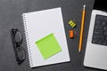 Notepad, office supplies and laptop on black leather workspace, top view with copy space Royalty Free Stock Photo