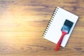 Notepad with paint brush on wood board background.using wallpaper for education, business photo.Take note of the product for book Royalty Free Stock Photo