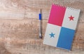 Notepad with Panama flag, pen on wooden background