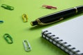 Notepad, paper clips and pen on a green surface Office supplies, Back to school Royalty Free Stock Photo