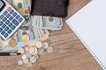 Notepad with pen, calculator, dollar bills on desk Royalty Free Stock Photo