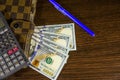 Notepad, pen, calculator and dollar bills on wooden table. Top v Royalty Free Stock Photo