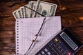 Notepad, pen, calculator and dollar bills on wooden table. Top v Royalty Free Stock Photo