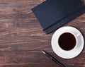 Notepad, pen and cup of black coffee on the wooden table Royalty Free Stock Photo