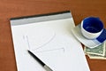 Notepad with pen and cup of coffee