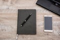 Notepad, pen, smartphone and part of the laptop on a wooden background Royalty Free Stock Photo