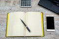 Notepad, pen, smartphone and part of the laptop on a wooden background Royalty Free Stock Photo