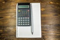 Notepad with pencil and calculator on wooden desk Royalty Free Stock Photo
