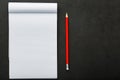 Notepad with a red pencil on a black stone plate background, for education, recording goals and deeds Royalty Free Stock Photo