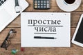 Russian text for prime numbers on note pad at office desktop