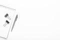 Notepad with silver stationery, pen on a white background. Office desktop. Copy space, top view, flat lay Royalty Free Stock Photo