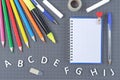 Notepad on spiral, school supplies and letters of the English alphabet. School concept