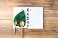 Notepad with spoon and leaf on wood board background.using wallpaper for education, business photo.Take note of the product for bo Royalty Free Stock Photo