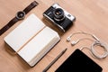 Notepad, tablet, earphones, camera watch and pen on wooden table Royalty Free Stock Photo
