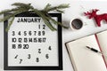 Notepad for taking notes of goals and plans for the new year, calendar,a cup of coffee, Christmas tree decorations on the desktop Royalty Free Stock Photo