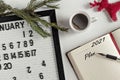 Notepad for taking notes of goals and plans for the new year, calendar,a cup of coffee, Christmas tree decorations on the desktop. Royalty Free Stock Photo