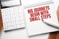 Notepad with text Big journeys begin with small steps on wooden background with calculator and red marker Royalty Free Stock Photo