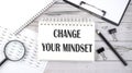 Notepad with text Change Your Mindset with a pen,office tools and graphs on the desktop Royalty Free Stock Photo