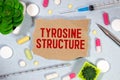 Notepad with the text and chemical structure of L Tyrosine on table with pills stethoscope