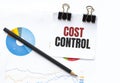 Notepad with text COST CONTROL on business charts and pen Royalty Free Stock Photo