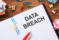 Notepad with the text DATA BREACH on the table with colored paper clips and crumpled sheets Royalty Free Stock Photo