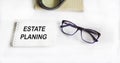 Notepad with text Estate Planning on white background with glasses, magnifier and diary Royalty Free Stock Photo