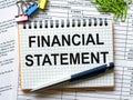 Notepad with text Financial Statement on white background with paper clips and pen Royalty Free Stock Photo