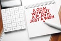 Notepad with text A goal without a plan is just a wish on wooden background with calculator and red marker Royalty Free Stock Photo