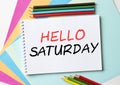 The Notepad with the text Hello Saturday is on colored paper with color pencils