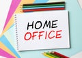 The Notepad with the text Home Office is on colored paper with color pencils Royalty Free Stock Photo