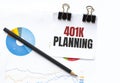 Notepad with text 401k planning on business charts and pen