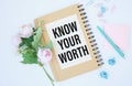 Notepad with text KNOW YOUR WORTH on deskt. Royalty Free Stock Photo