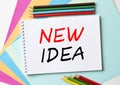 The Notepad with the text New Idea is on colored paper with color pencils Royalty Free Stock Photo