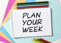 The Notepad with the text Plan Your Week is on colored paper with color pencils Royalty Free Stock Photo