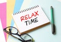 The Notepad with the text Relax Time is on colored paper with glasses and a pen Royalty Free Stock Photo