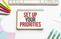 Notepad with text Set up your priorities. White background. Business