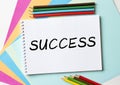 The Notepad with the text Success is on colored paper with color pencils Royalty Free Stock Photo