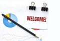 Notepad with text WELCOME on business charts and pen