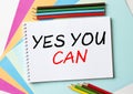 The Notepad with the text Yes You Can is on colored paper with color pencils Royalty Free Stock Photo