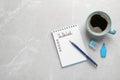 Notepad with unfilled To Do list, pen, marker and cup of coffee on grey marble table, flat lay. Space for text