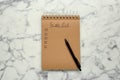 Notepad with unfilled To Do list and pen on white marble table, top view
