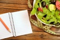 Notepad and vegetable salad Royalty Free Stock Photo