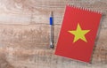 Notepad with Vietnam flag, pen on wooden background
