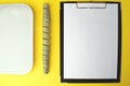 Notepad with a white sheet of paper for notes, next to it twisted centimeter and scale on a yellow background. To-do list. Copy Royalty Free Stock Photo