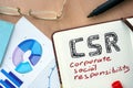 Notepad with word CSR corporate social responsibility concept. Royalty Free Stock Photo